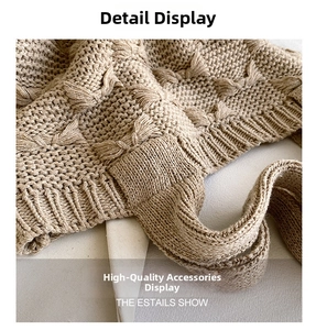 Detailed macro view of the beige chunky knit texture and twisted cable pattern of the bag