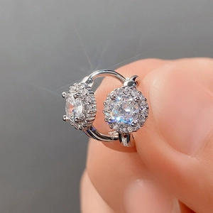 Macro shot of silver halo stud earring with sparkling cubic zirconia on a minimalist background