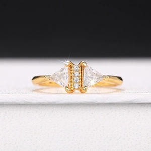 Macro shot of geometric triangle zircon ring with gold plating on a white leather box