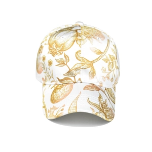 Detail of white baseball cap featuring gold floral print and six-panel construction