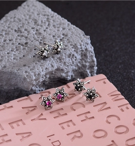 Macro shot of punk star cross earrings in vintage silver with colorful center stones