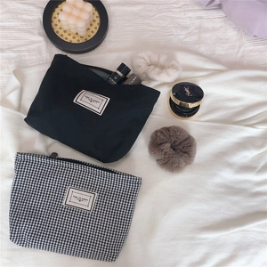 Close-up of black and checkered canvas cosmetic bags with Time To Party labels