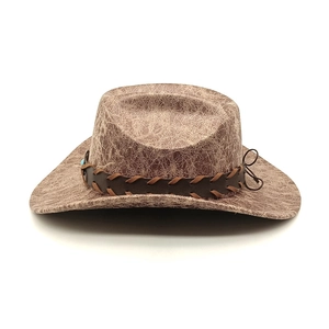 Detail of vintage brown cowboy hat featuring cracked texture and turquoise bead band
