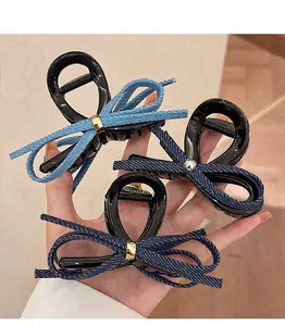 Détail de trois pinces à cheveux en denim avec boucle en métal et base brillante