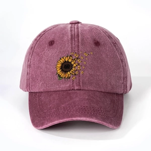 Detailed close-up of sunflower and butterfly print on washed burgundy denim baseball cap