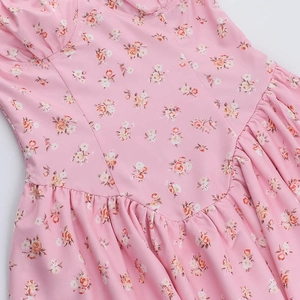 Détail de l'imprimé floral rose et des coutures à la taille de cette robe d'été légère