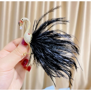 Elegant gold flamingo brooch with sparkling zircons and soft black feather tail detail