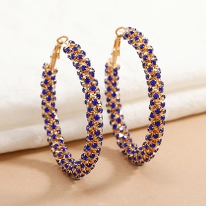 Macro detail of large gold hoop earrings with multi-row pavé blue rhinestones