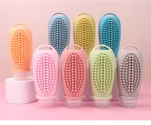 Macro shot of colorful silicone travel bottles featuring massage brush heads for hair care