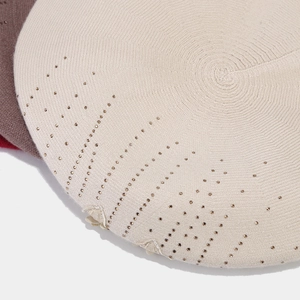 Detailed texture of cream knit beret featuring sparkling rhinestones and floral applique