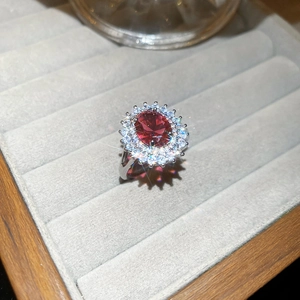 Gros plan d'une bague multicouche en argent avec zircon rouge et diamants sur velours