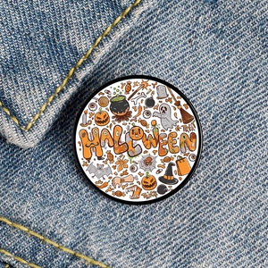 Close-up of Halloween badge with pumpkin and ghost motifs on blue denim fabric