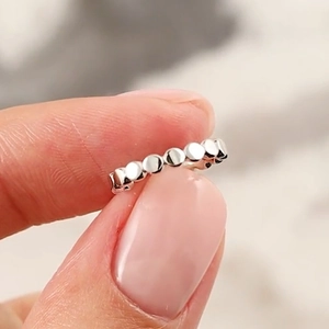 Macro shot of silver dotted geometric ear cuff with shimmering micro-paved metallic luster