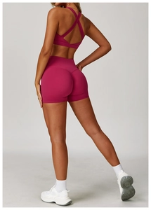 Dettaglio del set yoga rosa con reggiseno sportivo incrociato e pantaloncini a vita alta