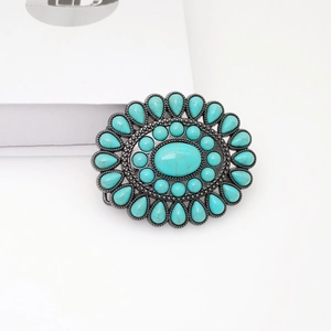Detail of vintage silver oval belt buckle with turquoise inlay and ethnic engraving