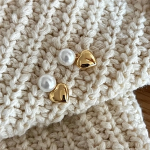 Elegant 925 silver heart pearl earrings displayed on a white knit sweater background