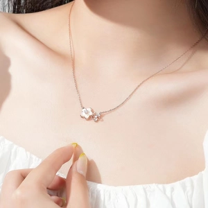 Elegant rose gold cherry blossom necklace featuring dual flower pendants and white pearls
