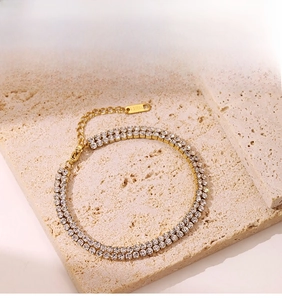 Detail of double-row gold-plated stainless steel tennis bracelet with white cubic zirconia