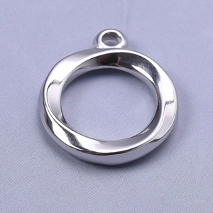 Macro shot of silver 304 stainless steel round pendant with wavy texture and top ring loop