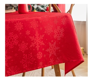 Close-up of red Christmas tablecloth featuring embossed snowflake patterns on fabric