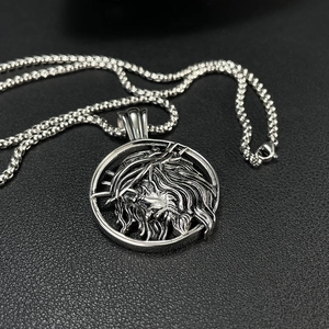 Macro shot of silver stainless steel circular pendant with Jesus thorn crown relief