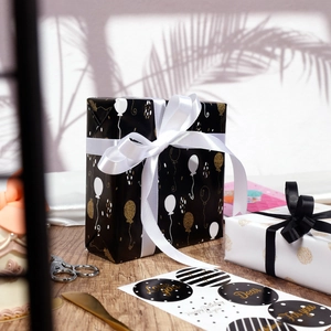 Gift wrapping set with black and gold balloon patterns, ribbons, and sealing stickers