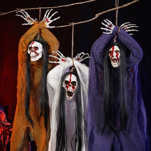 Three hanging Halloween skeleton ghosts in orange, white, and purple robes for party decor
