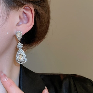 Detail of silver waterdrop tassel earrings with clear crystals on a model for elegant look
