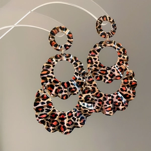 Detailed macro view of triple-layered leopard print earrings with scalloped edges