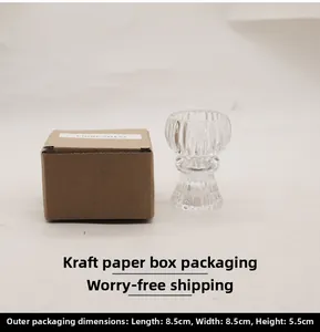 Close-up of ribbed glass candle holder next to its brown kraft paper packaging box