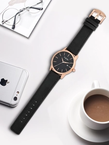 Detail view of TOMI minimalist quartz watch with black leather strap and calendar display