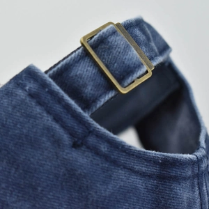 Macro view of navy corduroy baseball cap back with vintage bronze adjustable buckle