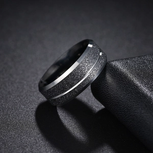 Macro shot of brushed stainless steel men's ring with matte finish and polished grooves