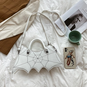 Close-up of white bat wing handbag with spider web stitching and silver spider clasp