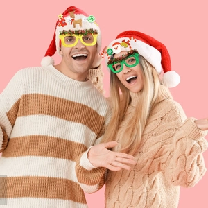 Festive Christmas glitter glasses with Santa and elk motifs worn by models in party setting