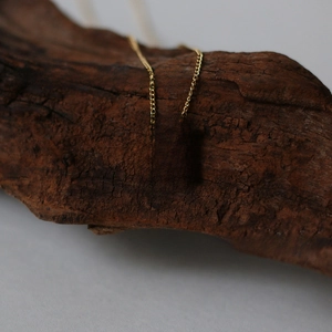 Macro shot of 18K gold plated vintage square pendant with 1967 engraving on wood