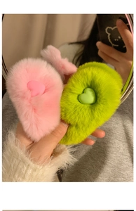 Detailed macro view of pink and neon green heart-shaped plush hair clips with soft faux fur