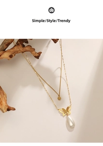 Close-up of double-layer 14K gold necklace with butterfly pendant and pearl charm
