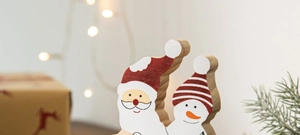Détail de décorations de Noël en bois avec Père Noël et bonhomme de neige étoilés