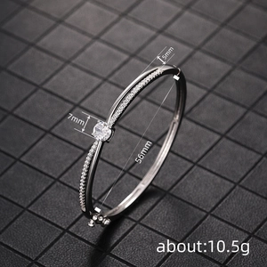 Elegant silver crossover bangle with round zircon center stone and dimensions 56mm inner diameter