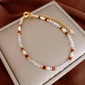 Detail of beaded bracelet with gold accents and colorful gemstones on a jewelry display