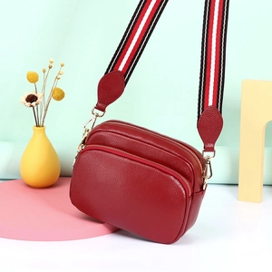 Rode crossbodytas van echt leer met lychee textuur en een brede kleurrijke riem