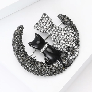 Detailed view of alloy crescent moon brooch featuring black enamel and rhinestone cats