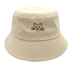 Close-up of cute cat embroidery and reinforced stitching on beige cotton bucket hat
