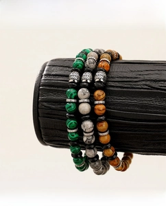 Close-up of three-piece beaded bracelet set featuring malachite and map stone textures