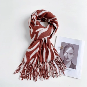 Detailed view of striped brown and beige cashmere scarf with elegant fringe edges