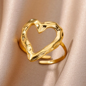 Adjustable gold heart ring with irregular lava texture on champagne silk background