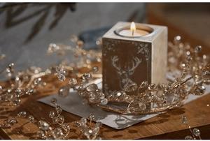 Close-up of crystal bead garland wrapped around a wooden candle holder for Christmas decor