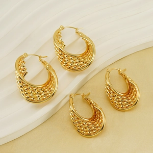 Macro detail of gold-plated twisted hoop earrings in large and small sizes