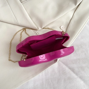 Lip-shaped creative box clutch in bright purple acrylic with a gold chain strap